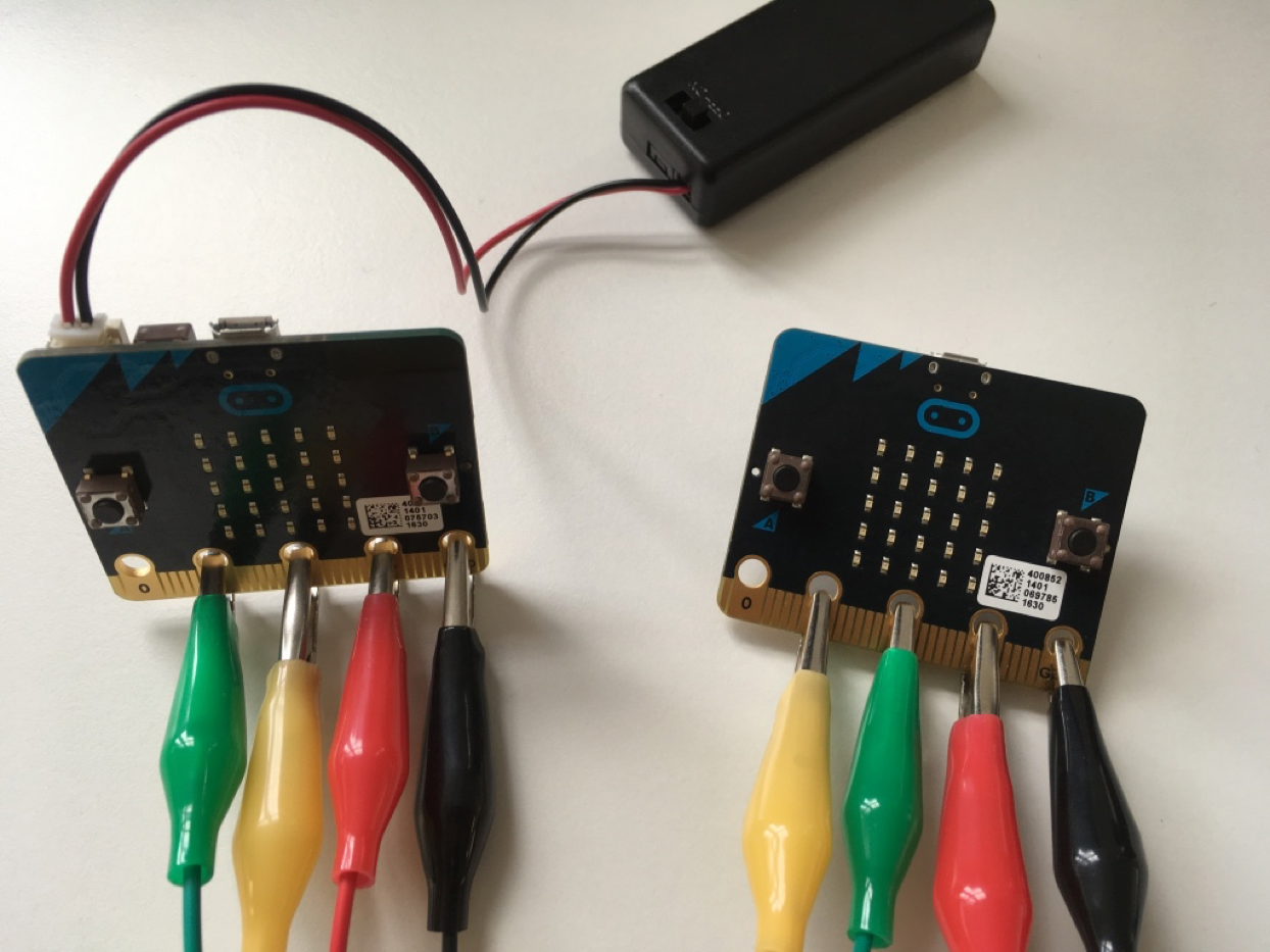 Wiring micro:bits.Two of the wires connect straight(3V-to-3V and GND-to-GND) but the other two cross over (1-to-2 and 2-to-1).